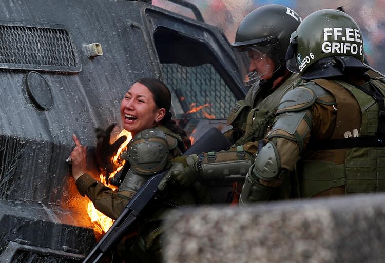Nedskæringspolitik og en stor ulighed i Chile har udløst særdeles voldsomme sammenstød mellem politi og demonstranter i hovedstaden. Her er en betjent ramt af en brandbombe. Foto: Jorge Silva/Ritzau Scanpix
