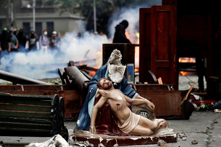 Et religiøst objekt ses ødelagt på gade i Santiago, Chile. Foto: Jorge Silva/Ritzau Scanpix