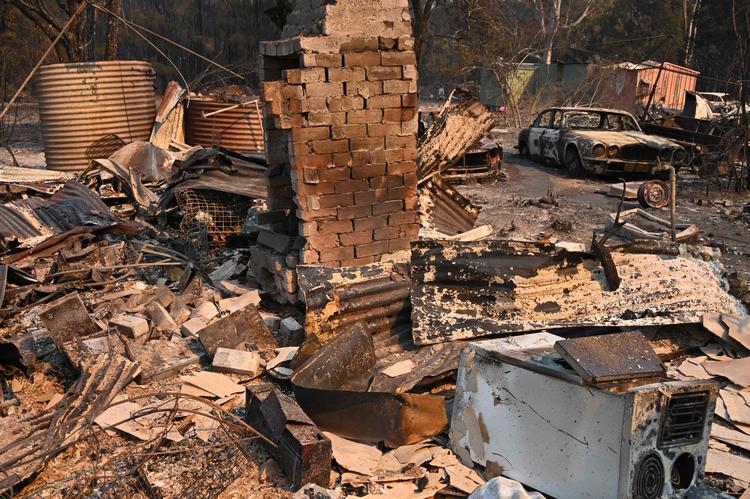 En vintage Jaguar efter den er fortæret af en brand i Old Bar, 350kilometer nord for Sydney. Brandfolk kæmper med over 100 skovbrande på østkysten. Men brandfaren vil stige i den kommende uge. Foto: Peter Parks/Ritzau Scanpix