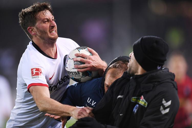 Det udløste tumultariske scener på sidelinjen, da David Abraham (tv.) efter at have torpederet modstanderens træner, Christian Streich, kom i klammeri med flere fra Freiburgs udskiftningsblænk. Foto: Patrick Seeger/Ritzau Scanpix