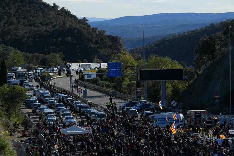 
   En kommende spansk regering står overfor fortsat uro i Catalonien. Mandag blokerede aktivister fra separatistgruppen Tsunami motorvej A7 mellem Spanien og Frankrig i protest mod fængslingen af løsrivelsesledere.  .
   Foto: Lluis Gene/Ritzau Scanpix