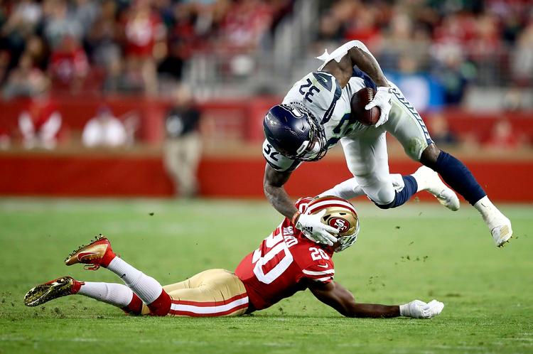 Chris Carson fra Seattle Seahawks (th.) undviger lige akkurat San Francisco 49ers' Jimmie Ward under den intense kamp natten til tirsdag dansk tid.  Foto: Ezra Shaw/Ritzau Scanpix