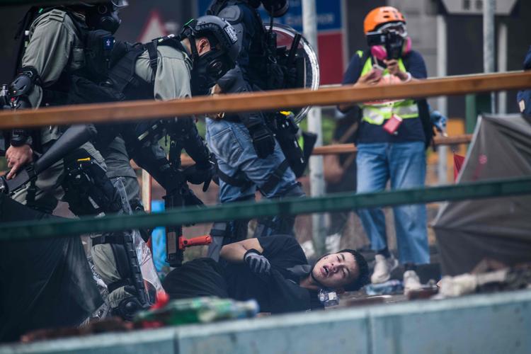 Hongkongs politi anholdt mandag nogle af de flere hundrede demonstranter, der havde barrikaderet sig på Hongkongs Polytekniske Universitet. Universitetet har været centrum for nogle af de hårdeste kampe de seneste måneder.  Foto: Anthony Wallace/Ritzau Scanpix