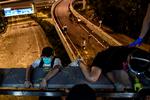 Demonstranter firede sig mandag nat lokal tid ned fra en motorvejsbro i et reb for at slippe væk fra Hongkongs Polytekniske Universitet og politiet. Da de nåede ned, blev de kørt væk af ventende motorcyklister. Foto: Ye Aung Thu/AFP
 Foto: Ye Aung Thu/Ritzau Scanpix