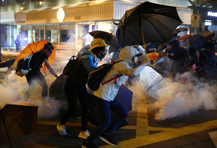 Demonstranterne forsøger at undvige den tåregas, som politiet har kastet i Hongkong.  Foto: Athit Perawongmetha/Ritzau Scanpix