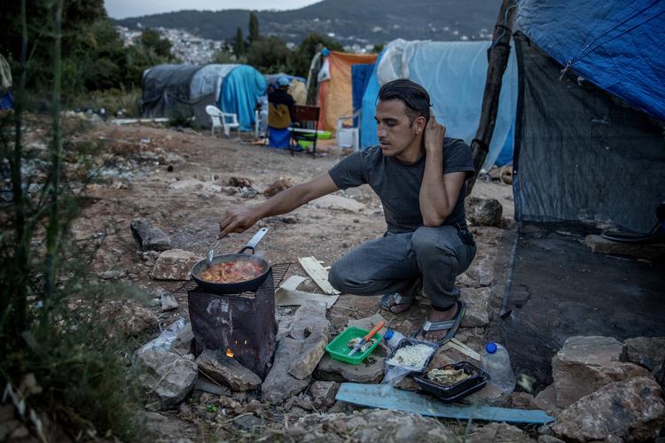 Forholdene for migranterne og flygtningene, som kommer til Grækenland, har været stærkt kritiseret. Nu oplyser den græske regering, at den lukker tre lejre - på Lesbos, Chios og Samos -  og åbner nye. På billedet ses lejren. Migranter har etableret improviserede lejre udenfor hegnene, de såkaldte Jungler, hvor de bor under ekstremt primitive forhold. Her ses en 30-årig iransk mand.  Foto: Jacob Ehrbahn/POLFOTO