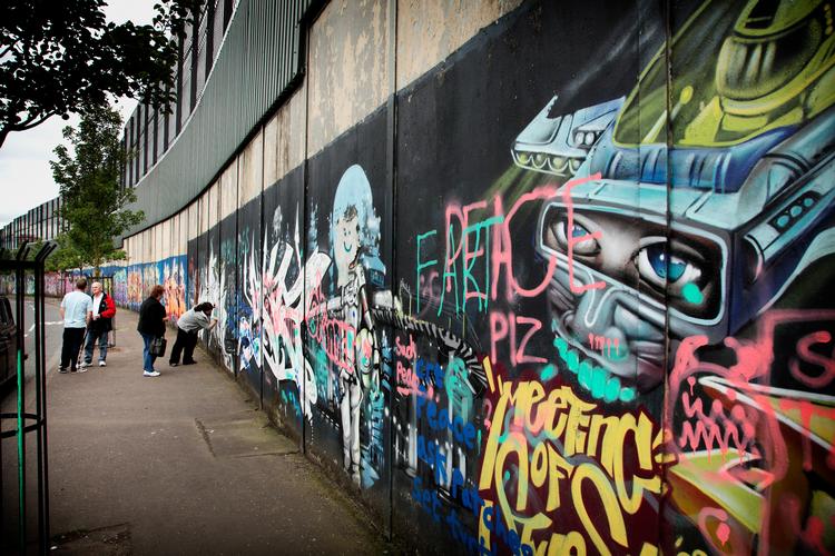 
   Den såkaldte Fredsmur<AS> i Belfast adskiller protestantiske <AS>Shankill Road fra katolske  Falls Road. Turister er glade for graffitien.  Foto: Morten Langkilde/Ritzau Scanpix