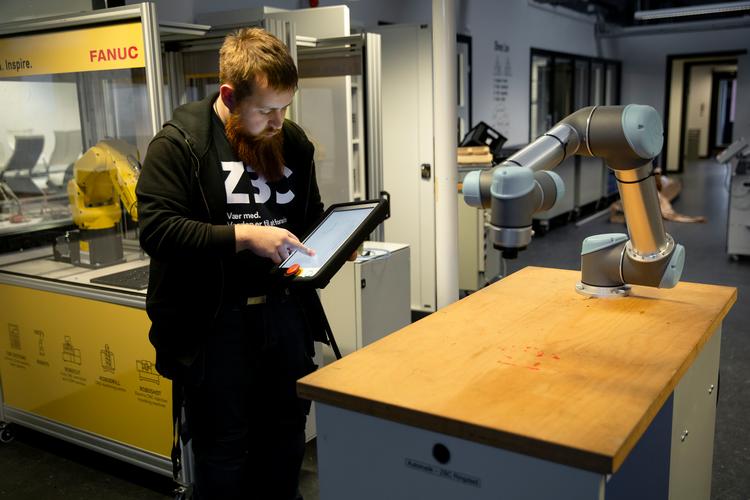 I undervisningen på ZBC i Ringsted lærer eleverne på automatik- og procesuddannelsen at programmere en robotarm som denne, så den kan sortere metal- og plastikklodser ved hjælp af en lille sensor, som registrerer klodsens type.  Foto: Nima Taheri/POLFOTO