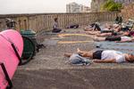 Laura Hubaide, der kommer til yogatimen med sit board på knallerten, starter med en afslapning, hvor alle skal ligge som et lig. Hvilket ikke er svært efter en lang dags surfen på stranden nedenfor. Foto: Per Munch