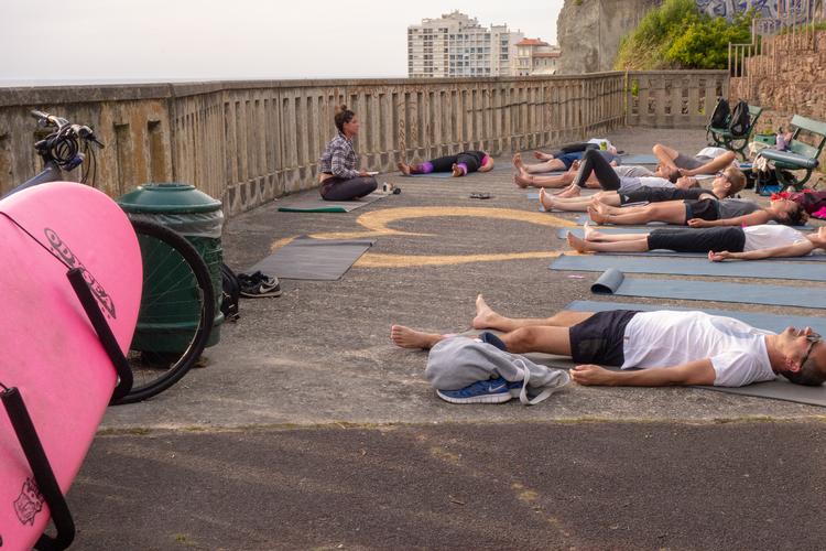 Laura Hubaide, der kommer til yogatimen med sit board på knallerten, starter med en afslapning, hvor alle skal ligge som et lig. Hvilket ikke er svært efter en lang dags surfen på stranden nedenfor. Foto: Per Munch