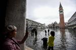 Adriaterhavet er trængt helt ind i Venedig. Turister tager billeder af Markuspladsen under vand.  Foto: Miguel Medina/Ritzau Scanpix