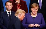 Frankrigs  præsident, Emmanuel Macron, Tysklands kansler,  Angela Merkel poserer til det årlige Nato-'familiefoto', mens den amerikanske præsident, Donald Trump, går forbi dem. Det 70. Nato-topmøde fandt sted ved London.  Foto: Christian Hartmann/Ritzau Scanpix