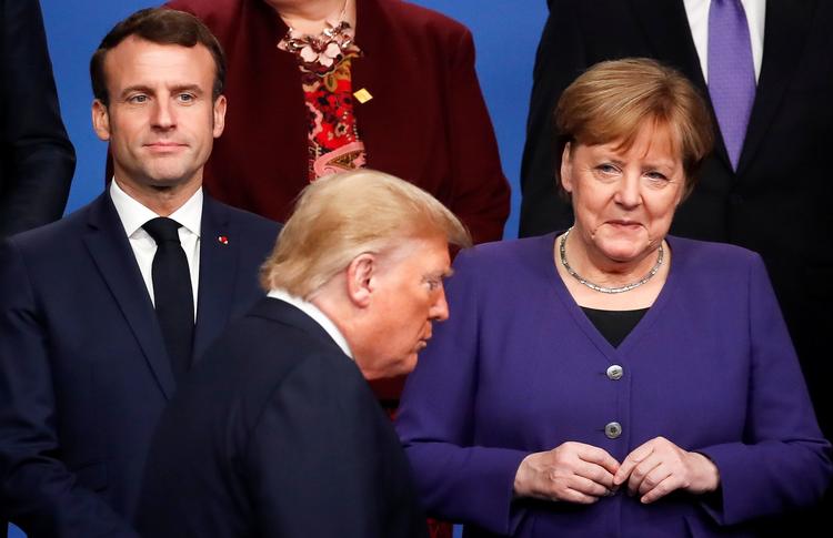 Frankrigs  præsident, Emmanuel Macron, Tysklands kansler,  Angela Merkel poserer til det årlige Nato-'familiefoto', mens den amerikanske præsident, Donald Trump, går forbi dem. Det 70. Nato-topmøde fandt sted ved London.  Foto: Christian Hartmann/Ritzau Scanpix
