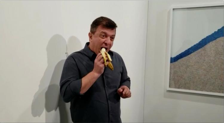 David Datuna spiser Maurizio Cattelans værk 'Comedan' og døber sin performance 'Hungry Artist'. Foto: Ronn Torossian/Ritzau Scanpix