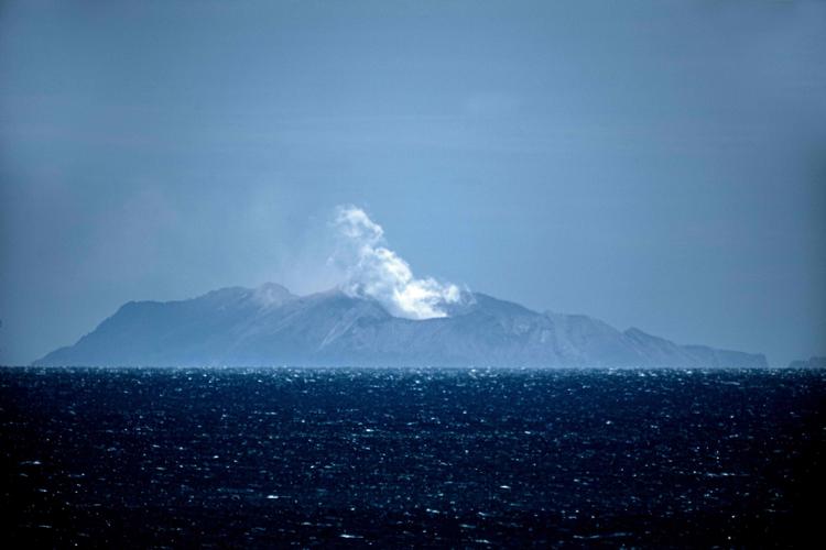Røg ses stige op fra White Island på New Zealand. Fem personer er blevet dræbt, da vulkanen mandag gik i udbrud. Der var i alt 47 personer på den ubeboede ø, da det skete. 8 personer savnes fortsat. Foto: Marty Melville/Ritzau Scanpix