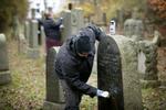 Mere end 80 gravsten blev overhældt med maling på den jødiske gravplads Østre Kirkegård i Randers. Stenhuggerne Jesper ( i forgrunden) og Malene Kriegbaum samt Mikael Hansen på at udbedre skaderne.
   Foto: Jens Dresling/POLFOTO