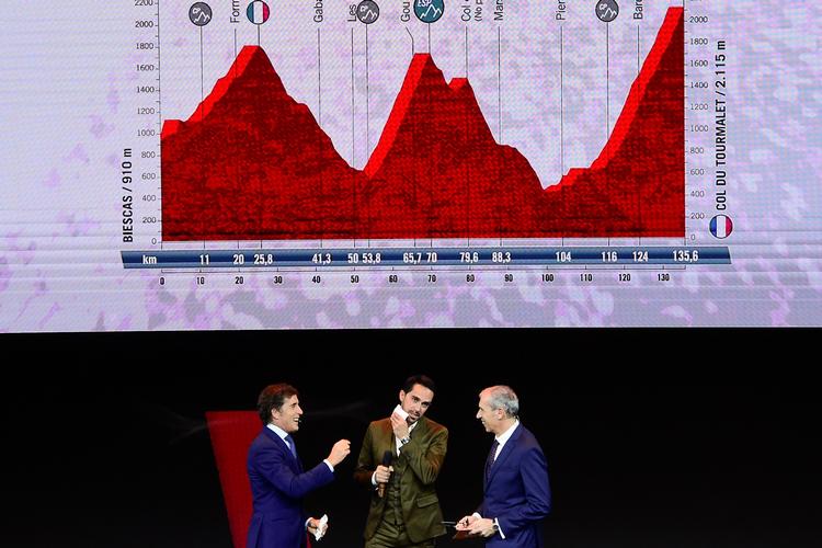 Alberto Contador (i midten) ser noget betænkelig ud, mens humøret synes højere hos de to spanske tv-kommentatorer Pedro Delgado (t.v.) og Carlos de Andres ved præsentationen af ruten til næste års Vuelta a España, hvor det er profilen af etapen til Col du Tourmalet, der vises bag grunden..
 Foto: Oscar del Pozo/Ritzau Scanpix