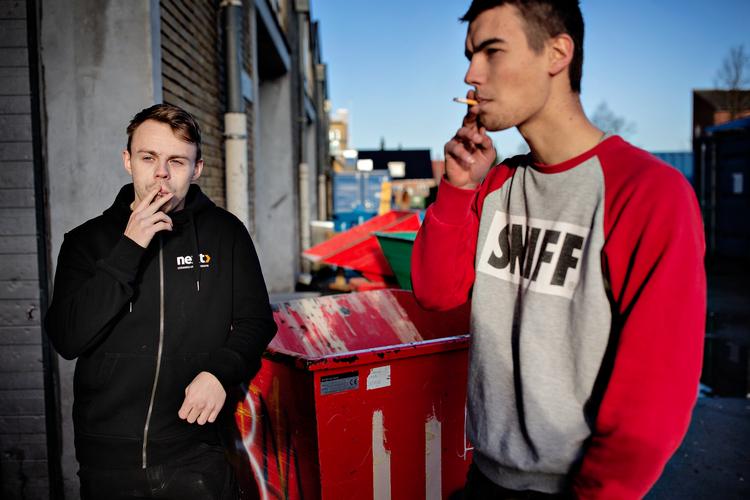 Patrick Sindt og Victor Zachariasen får en smøg foran tømrerværkstedet på erhvervsskolen NEXT i Rødovre. De tror, at det vil blive svært at holde øje med, om eleverne ryger på trods af et forbud.  Foto: Martin Lehmann/POLFOTO