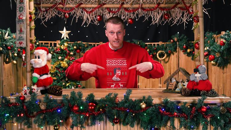 Vært Mathias Bach fremviser sin Britta Nielsen-juletrøje. For den uindviede kan TV 2 Echo minde en hel del om et mix mellem DR3 og Vice. Foto: TV 2 Echo