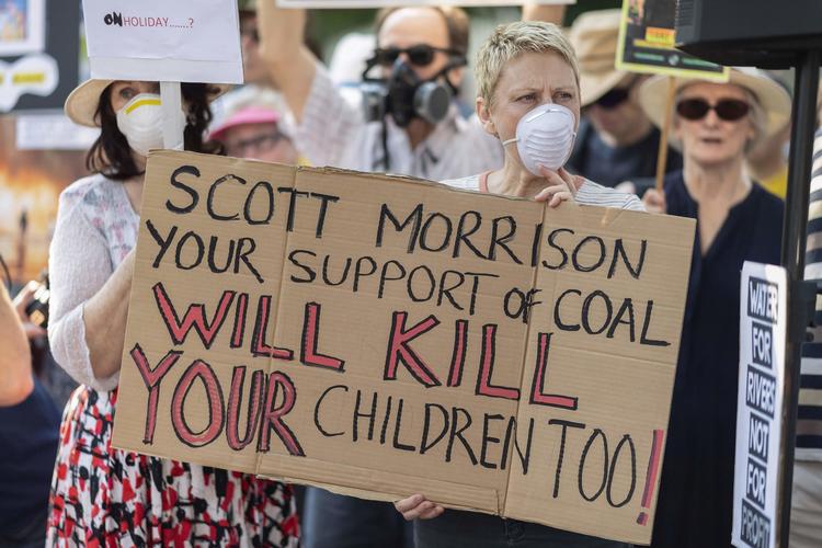 'Scott Morrison, din støtte til kul vil dræbe vores børn', står der på skiltet ved klimademonstrationen i Sydney 19. december.  Foto: Wendell Teodoro/Ritzau Scanpix