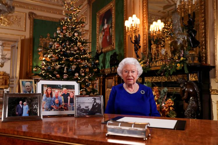 Storbritanniens dronning Elizabeth II's juletale sendes på britisk tv første juledag. Kommentatorer har bidt mærke i, at Prins Harry og prins Andrew mangler blandt de familiefotos, der er stillet op på dronningens skrivebord.    Foto: Pool New/Ritzau Scanpix