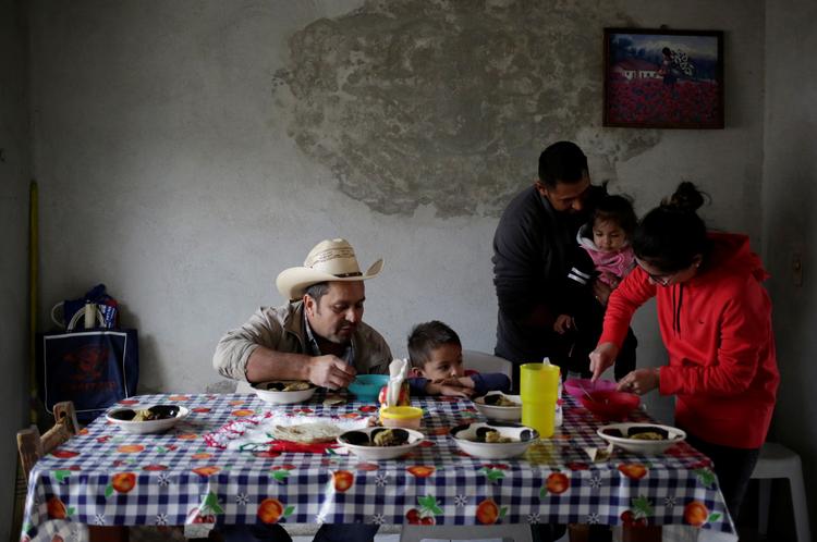 Sikkert fremme i Mexico skal Jesus Mendoza med sin 1-årige datter i armene til at spise sammen med resten af familien. De er kørt hertil i en stor karavane fra USA sammen med 1.500 andre. Foto: Daniel Becerril/Ritzau Scanpix