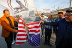 Irakiske demonstranter afbrænder et amerikansk flag efter USAs bombardement af baser for militsen Kataib Hizbollah.. Foto: Alaa Al-marjani/Ritzau Scanpix