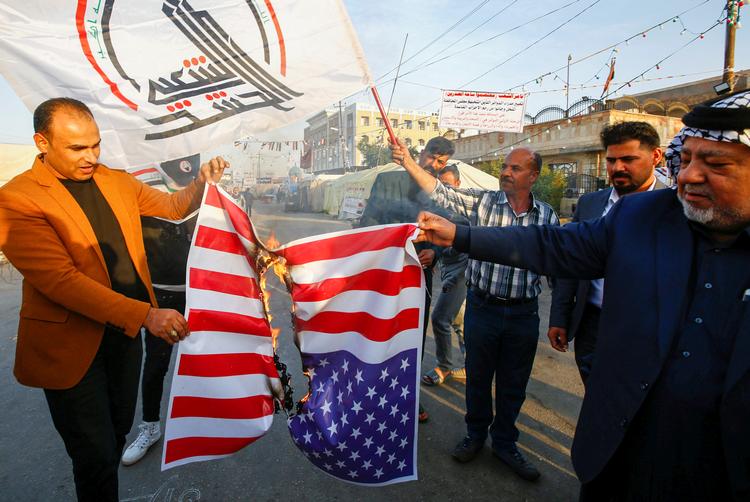 Irakiske demonstranter afbrænder et amerikansk flag efter USAs bombardement af baser for militsen Kataib Hizbollah.. Foto: Alaa Al-marjani/Ritzau Scanpix