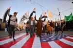 Vrede irakere træder på det amerikanske flag under en demonstration i dag.  Foto: Haidar Hamdani/Ritzau Scanpix