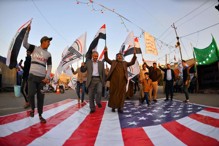 Vrede irakere træder på det amerikanske flag under en demonstration i dag.  Foto: Haidar Hamdani/Ritzau Scanpix
