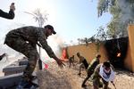 Demonstranter fra Hashd al-Shaabi-militsen tænder bål op ad muren omkring den amerikanske ambassade i Bagdad. Foto: Thaier Al-sudani/Ritzau Scanpix