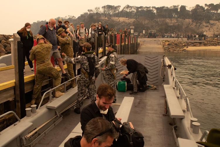 Fredag måtte den australske flåde evakuere folk fra Mallacoota i delstaten Victoria. Forsvaret er begyndt at evakuere folk, som er fanget i de omfattende skovbrande.
     
   Foto: Helen Frank/Ritzau Scanpix