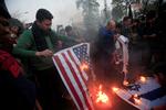 Under en protest i Pakistan, brænder tilhængere af den afdøde Qassem Sulaimani det amerikanske og det israelske flag. De mener, at de to lande har samarbejdet om droneangrebet. Foto: Mohsin Raza/Ritzau Scanpix