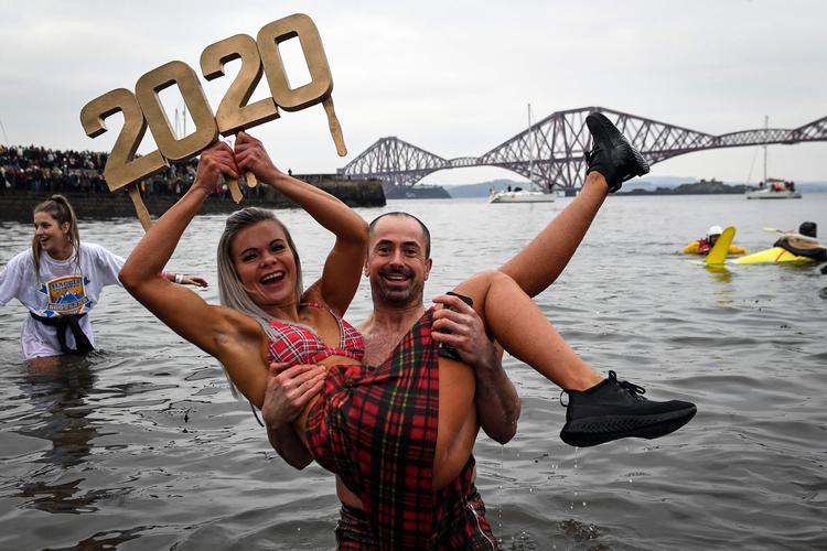 »To tusind og tyve« eller »tyve-tyve«? Her er vi til den traditionelle nytårsdukkert i South Queensferry i Skotland. Foto: Andy Buchanan/Ritzau Scanpix