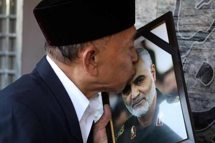 En mand kysser et billede af den afdøde Qassem Soleimani, der blev dræbt for nogle dage siden i et amerikansk luftangreb. Foto: Lim Huey Teng/Ritzau Scanpix