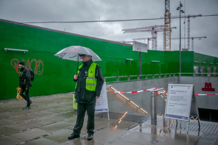 I regnvejr står der en servicemedarbejder, klar til at hjælpe alle dem med spørgsmål til den lukkede metroring.  Foto: Miriam Dalsgaard/POLFOTO