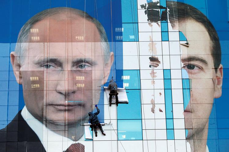 Arbejdere i færd med at sætte en stor plakat op af Putin og Medvedev. Sidstnævnte har trukket sig som regeringsleder som konsekvens af Putins planer om at ændre forfatningen. Foto: Eduard Korniyenko/Ritzau Scanpix