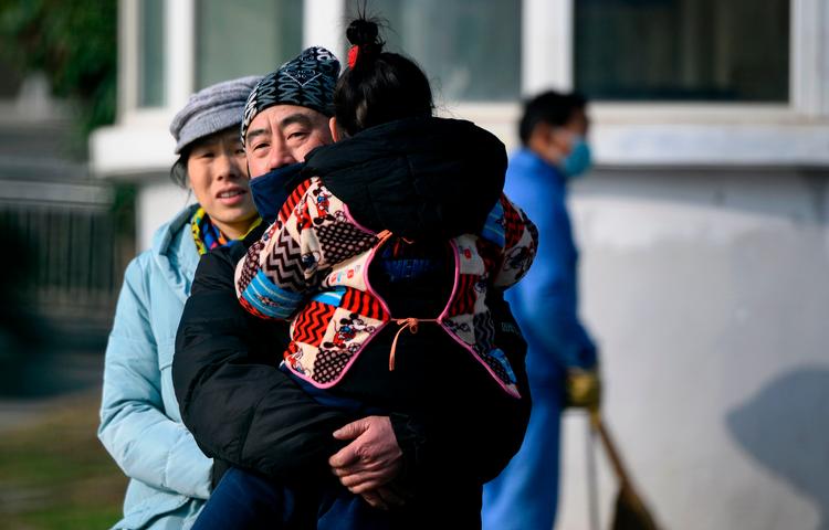 En familie forlader det hospital i Wuhan, Kina, hvor den nye virus krævede sit første dødsoffer, en 61-årig mand. Myndighederne i Kina oplyser foreløbigt om 201 smittede i Kina, to i Thailand og en i Japan.  Foto: Noel Celis/Ritzau Scanpix
