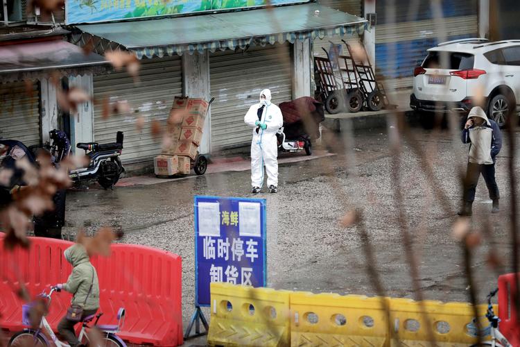 En sundhedsmedarbejder i beskyttelsesdragt ses ved det marked i den kinesiske by Wuhan, hvor det nye virus angiveligt opstod.
 Foto: Darley Shen/Ritzau Scanpix