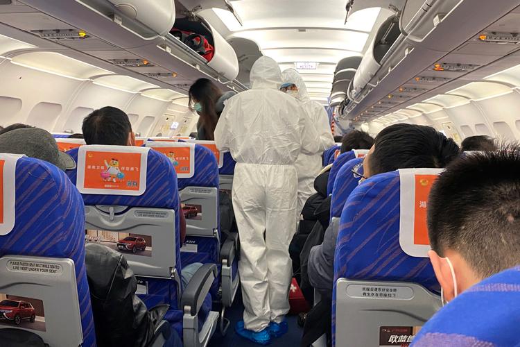 Sundhedsarbejdere tjekker en passagers tilstand, da et fly fra Changsha er landet i Shanghai. Foto: David Stanway/Ritzau Scanpix