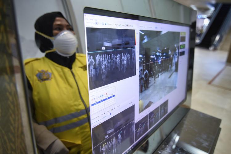 En sundhedsansat i Lomboks Internationale Lufthavn i Praya i Indonesien er klar til at skanne passagerer efter udbruddet af coronavirussen i Kina.  Foto: Moh El Sasaky/Ritzau Scanpix