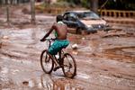 En mand cykler gennem en gade i Belo Horizonte i delstaten Minas Gerais. Byen blev oversvømmet, da floden Das Velhas River løb over sine bredder. Foto: Douglas Magno/Ritzau Scanpix
