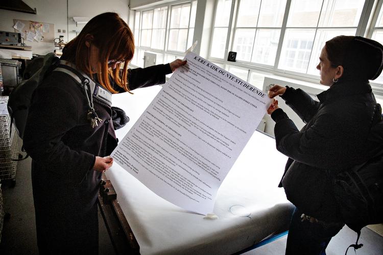Tredjeårsstuderende Martha Abild Kristensen og Edith Baunbæk Wallentin står med en printet plakat af protestskrivelsen, som i sin fulde størrelse blev fjernet af uddannelsesledelsen.  Foto: Martin Lehmann/POLFOTO
