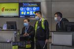 Ansatte fra det kinesiske  luftfartsselskab Air China bærer maske ved indtjekningsskranken i lufthavnen i San Francisco. Foto: David Mcnew/Ritzau Scanpix