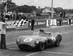 Carroll Shelby tager det ternede flag som vinder af Le Mans i 1959. Det er Aston Martins hidtil eneste sejr i den samlede stilling i det generelle klassement. Det er yderligere blevet til en række klassesejre. 
   Foto: Uncredited/Ritzau Scanpix