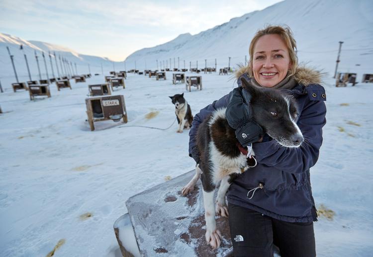 Karina Bernlow har boet 22 år i Arktis og driver sammen med sin mand, Martin Hartmann Munck,  'Green Dog ' på Svalbard med 300 slædehunde og arrangerer slædeture for turister.  Her sidder hun med Aunt.  Foto: Morten Langkilde
