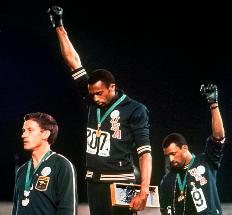 Tommie Smith (i midten) og  John Carlos udtrykte støtte til Black Panthers-gruppen på sejrsskamlen efter 200 meterløbet ved OL i Mexico City i 1968. Peter Norman, der vandt sølv, var  taget med på råd og udtrykte stille støtte til amerikanerne.  Foto: Stf/Ritzau Scanpix