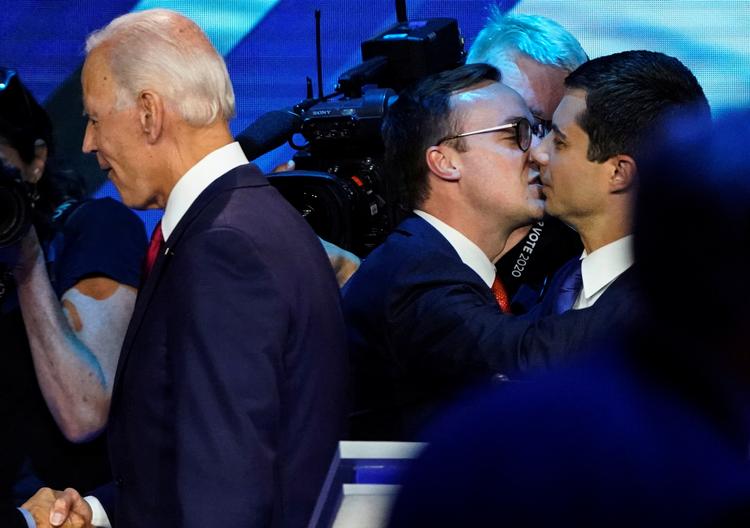 Pete Buttigieg får et kys af sin mand, Chasten.  Foto: Mike Blake/Ritzau Scanpix