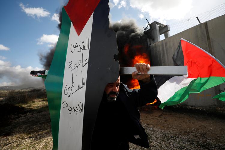 En demonstrant bærer en model af et kort med farverne på det palæstinensiske flag, hvor der står 'Jerusalem er den evige hovedstad i Palæstina'.    Foto: Mohamad Torokman/Ritzau Scanpix