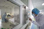 En sundhedsarbejder kontakter sin kollega i en isoleret stue på Jinyintan Hospitalet i Wuhan.  Foto: China Daily/Ritzau Scanpix